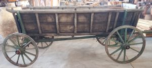 old wooden wagon (carriage) , with a green color on the wheels and part of the carriage