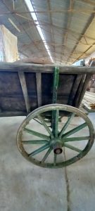 old wooden wagon (carriage) , with a green color on the wheels and part of the carriage