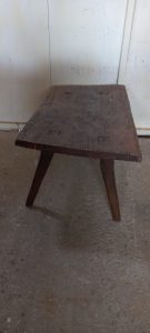 coffee table made by hand of old wood , short , slightly asymmetrical, restored ,  antique, vintage