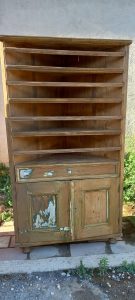 old wooden bookcase-vitrine-cabinet, in an original triangular shape, in natural wood color, with shelves, drawer and a bottom cabinet