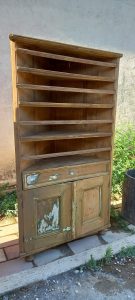 old wooden bookcase-vitrine-cabinet, in an original triangular shape, in natural wood color, with shelves, drawer and a bottom cabinet