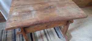 old wooden table, in dark colored wood, handmade ,restored, with an original setting of the base with a part of an old wine/tobacco press