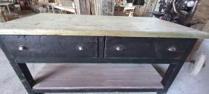 old wooden table-desk, workbench, industrial furniture, industrial design, in a dark color, with a light-colored top, two drawers and a light-colored shelf at the bottom part