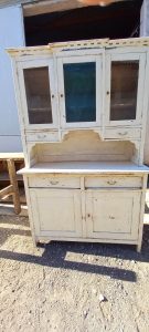 old wooden sideboard, kitchen furniture, with cupboards with windows on the top part of the furniture, drawers and storing space at the bottom (cupboards), in white color with leftover blue original color,