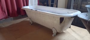 old cast iron  free standing bath tub, with four legs, rounded on the edges, white colored, heavy piece, retro style
