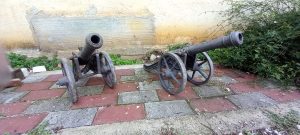 pair of old canons from cast iron with decorative patterns on the canon and on the side , decorative architectural element