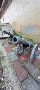 pair of old canons from cast iron with decorative patterns on the canon and on the side , decorative architectural element