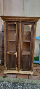 old wooden window case- bookcase  in a natural color of wood, old wooden storage piece of furniture with window, three horizontal curved columns and curving on the top part