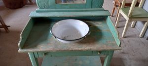 old wooden wash stand with a mirror and small drawers, old wooden table for porcelain bowl pitcher in turquoise color, handmade, with iron basin and curving on the side