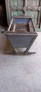 old baby cot- cradle , old handmade baby cot in a grey cot