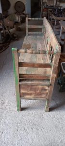 old wooden sofa in a washed-out green color with carvings on the back and the handles , with storage space, handmade, ideal for a veranda decoration or by the fireplace, rustic style