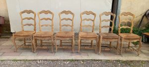 set of six wooden chairs, handmade with a straw seat, rustic style, carvings on the back and the legs, in natural color wood