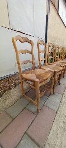 set of six wooden chairs, handmade with a straw seat, rustic style, carvings on the back and the legs, in natural color wood