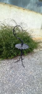 old iron floor tripod candle holder in black color, elaborately decorated with rose  branches and roses, with a tray and a place to hold a hanging light, candelabra, candelabrum, candle stick