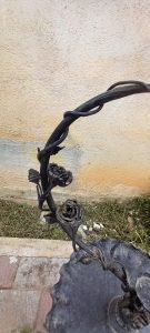 old iron floor tripod candle holder in black color, elaborately decorated with rose  branches and roses, with a tray and a place to hold a hanging light, candelabra, candelabrum, candle stick